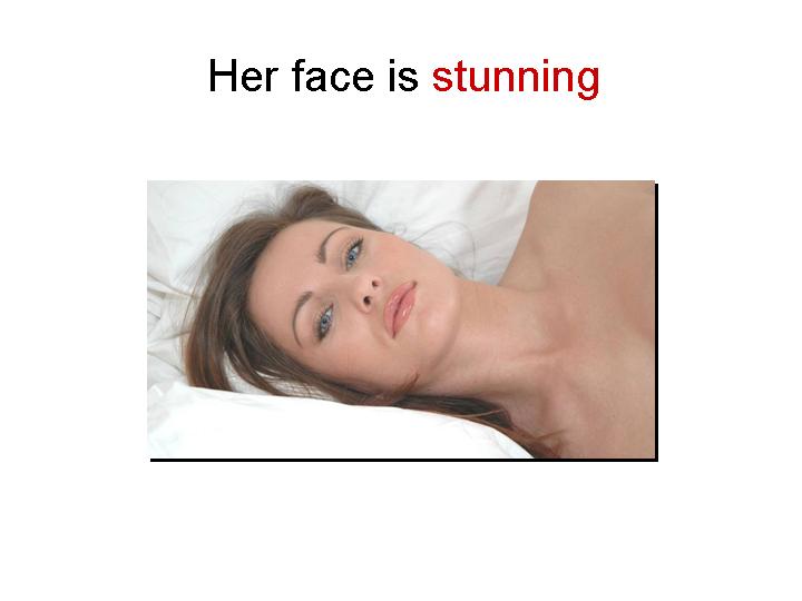 A close-up image of a woman lying on a bed with a neutral expression, showcasing her stunning face.