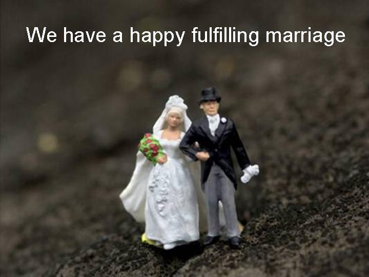 A close-up of a miniature wedding couple, featuring a bride in a white dress and bouquet and a groom in a tuxedo, placed on a textured surface with a caption about a happy marriage.