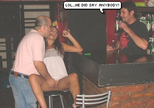 A man kisses a woman sitting on a bar stool while another man observes and smiles, with a comic speech bubble that reads 'LOL...he did say anybody!'